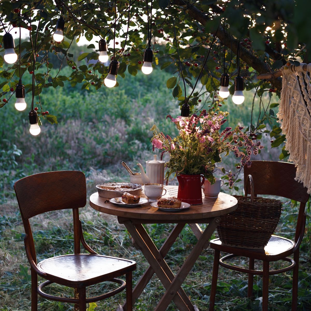 A small romantic spot in the backyard with a table set in the dim lights. 