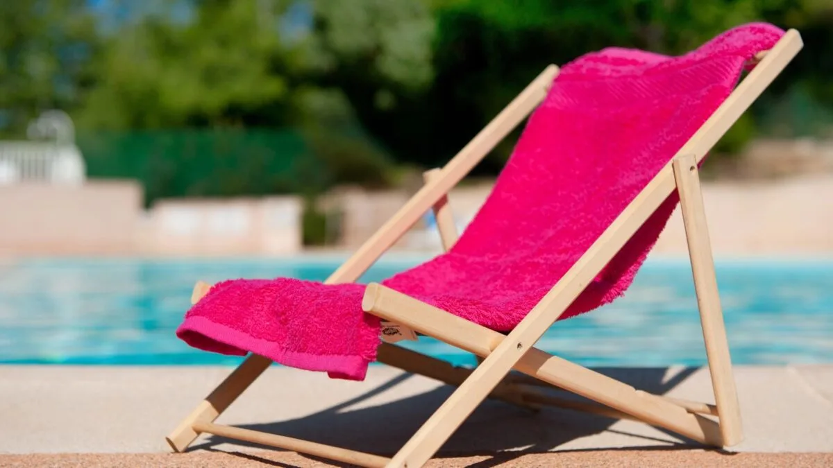 beach chair covered with a fuchsia colored towel. 
