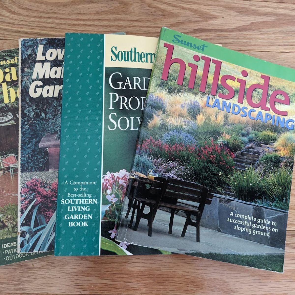 Gardening magazines laying on a wooden floor.