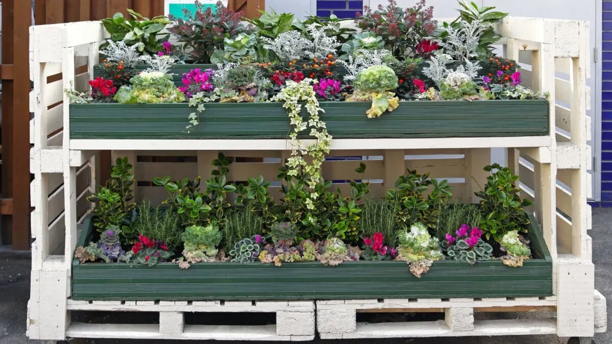 A busy pallet garden with a variety of plants in many colors. 