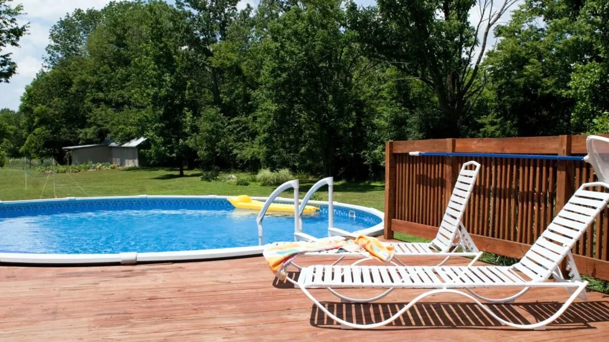 wooden deck and white beach chairs by the pool.