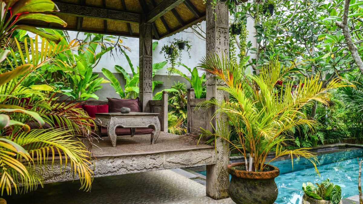 a cozy gazebo by the swimming pool, surrounded by lush greenery.