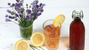 Homemade lavender syrup in a bottle and lemonade. Made from fresh aromatic lavender flowers, sugar or honey and lemon juice