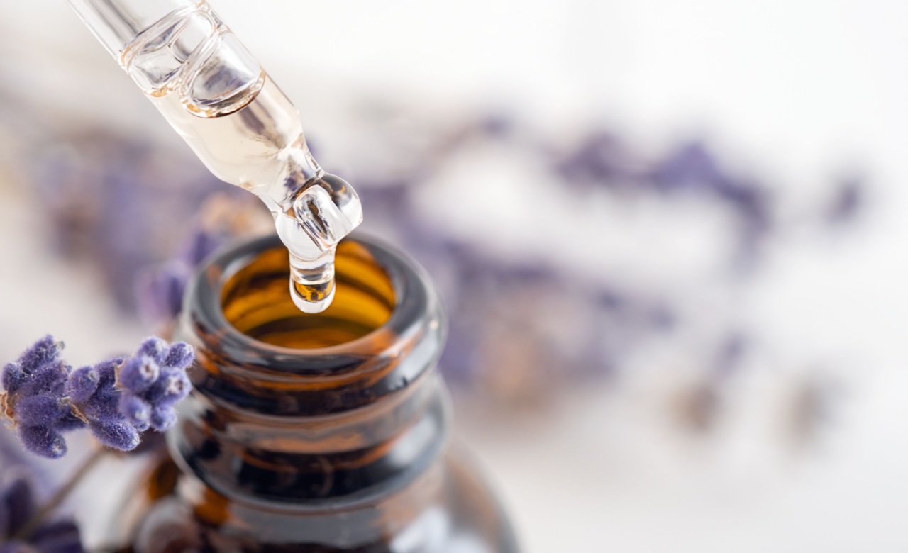 Essential oil with a dropper pipette and lavender branches on a white background with copy space. Brown glass cosmetic bottle, serum.