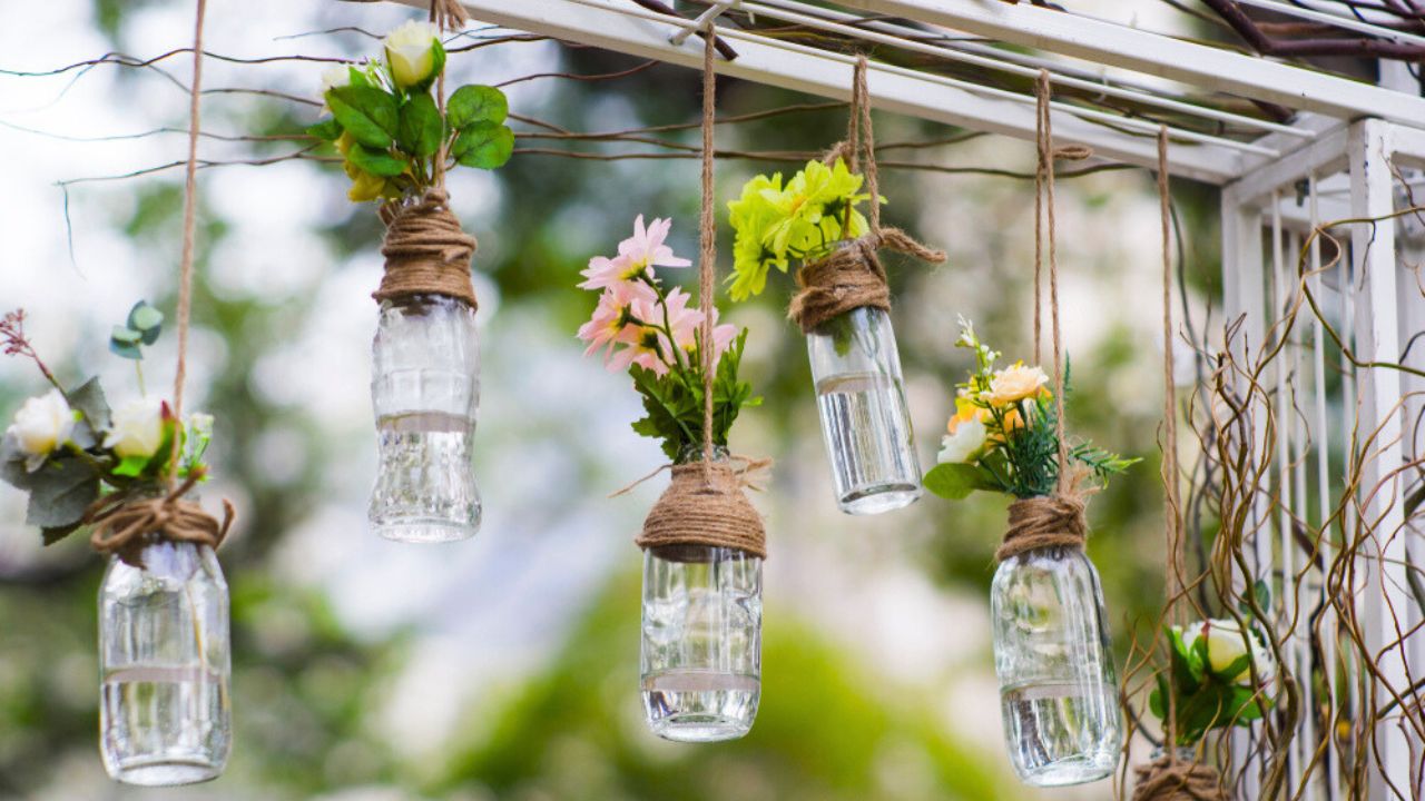 DIY old empty bottles can be used for event decoration as a flowers vases hand from bars