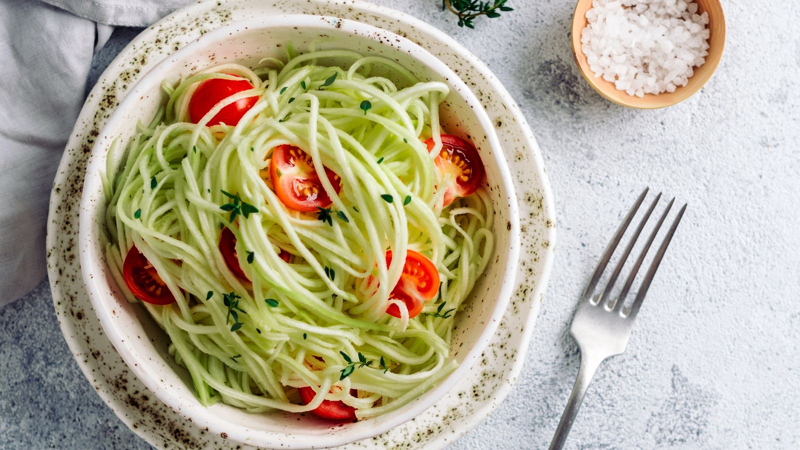 a plate of zucchini pasta with cherry tomatoes.