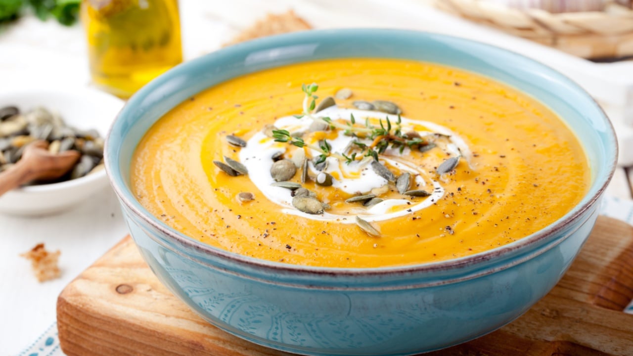 Roasted pumpkin and carrot soup with cream and pumpkin seeds