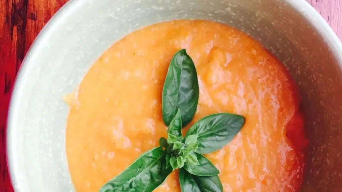 A bowl of butternut squash, sweet potato, and carrot soup.