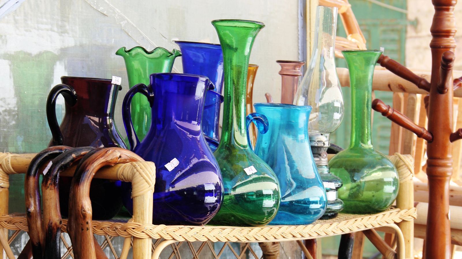 A shelf with colorful glass vases in tea thrift shop.