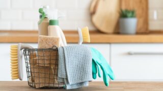 Basket with brushes, rags, natural sponges and cleaning products