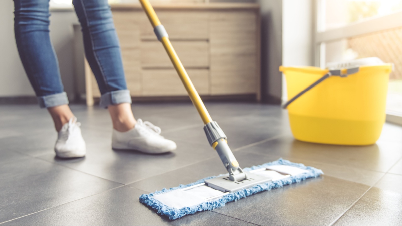 Cropped image of beautiful young woman in protective gloves using a flat wet-mop while cleaning floor in the house