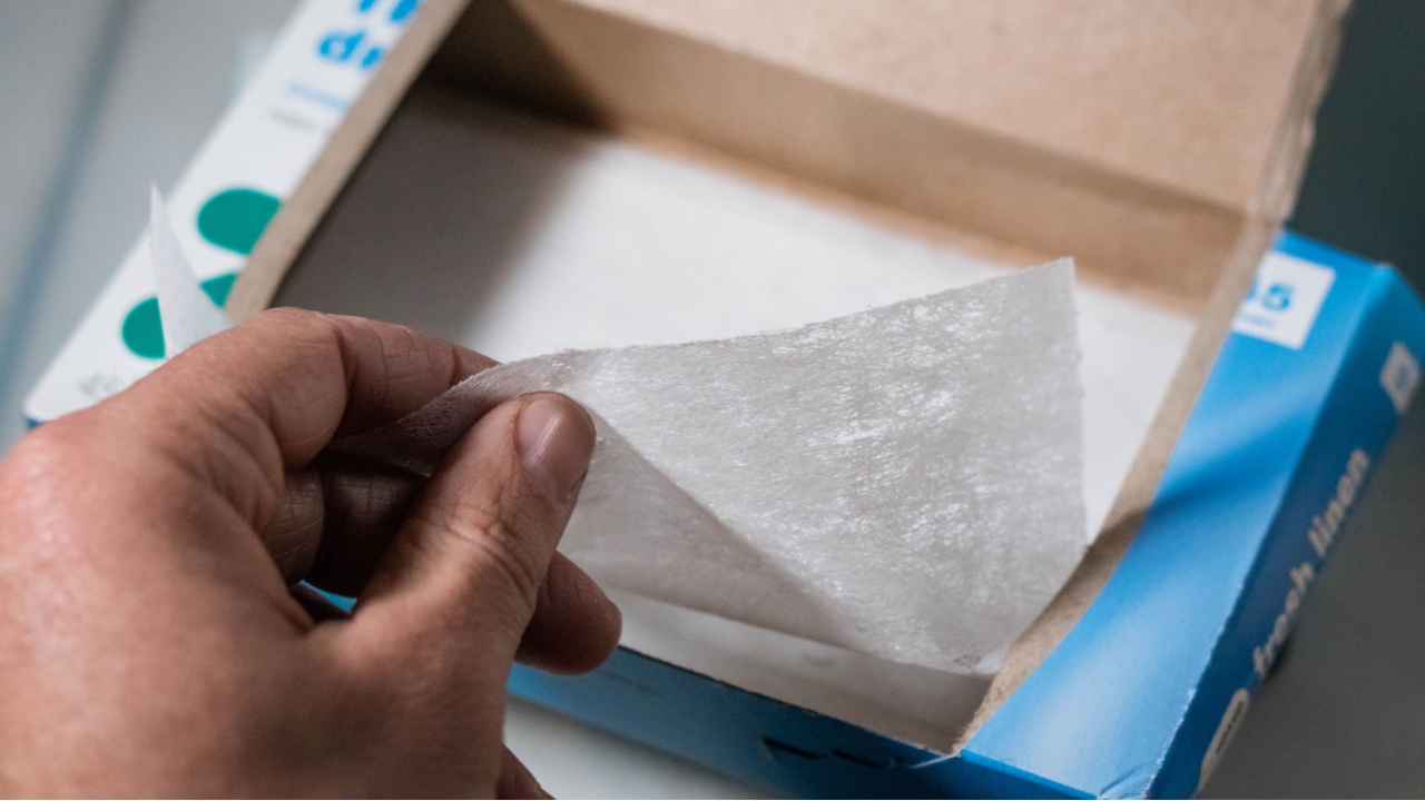 Cumberland, Rhode Island/ USA- March 31, 2019 a box of laundry dryer sheets being placed on top of a dryer with the rest of the laundry cleaning products