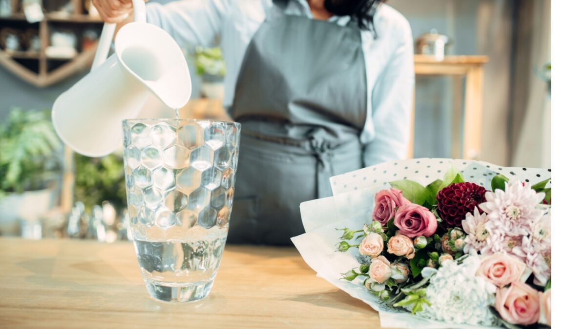 Florist pours water into a vase in flower shop