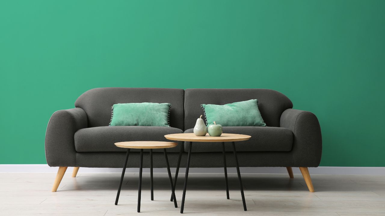 Room with Sea Green Walls, black sofa and two coffee tables