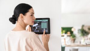 Woman using smart home security system control panel