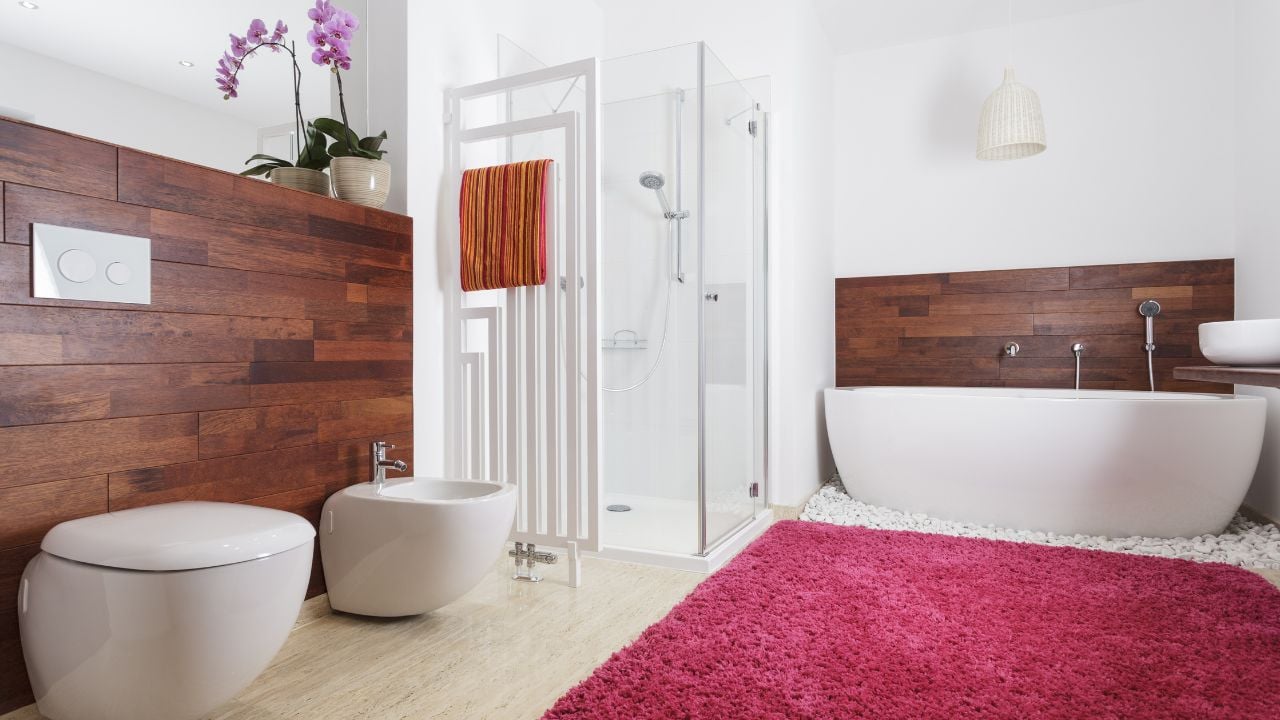 Interior of a modern bathroom with pink carpet and wooden wall