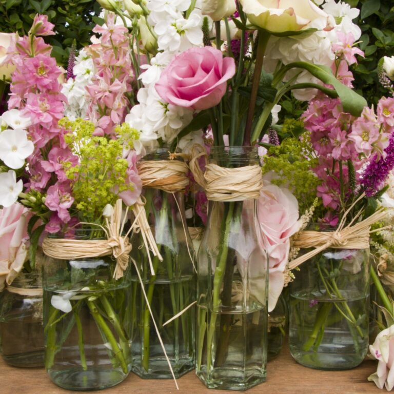 close up image of flower arrangements in jam jars