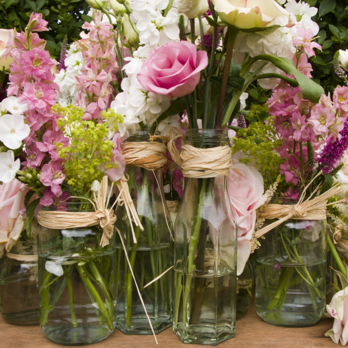 close up image of flower arrangements in jam jars