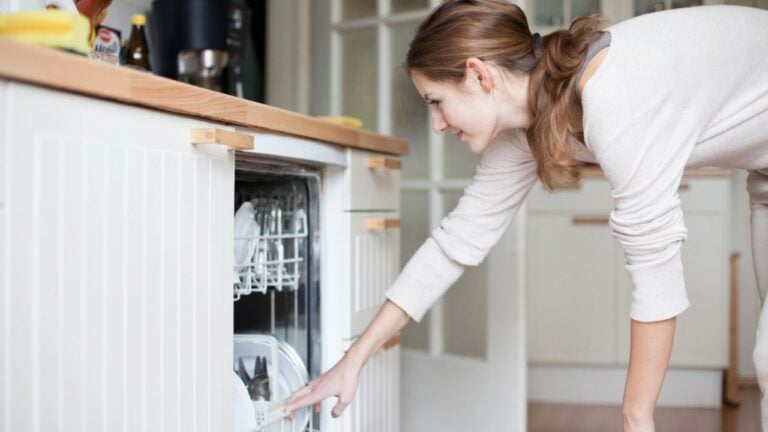 woman opening her dishwasher in the kitchen