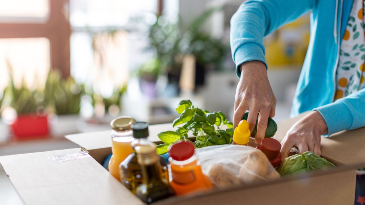 Young woman unpacking boxes of food at home