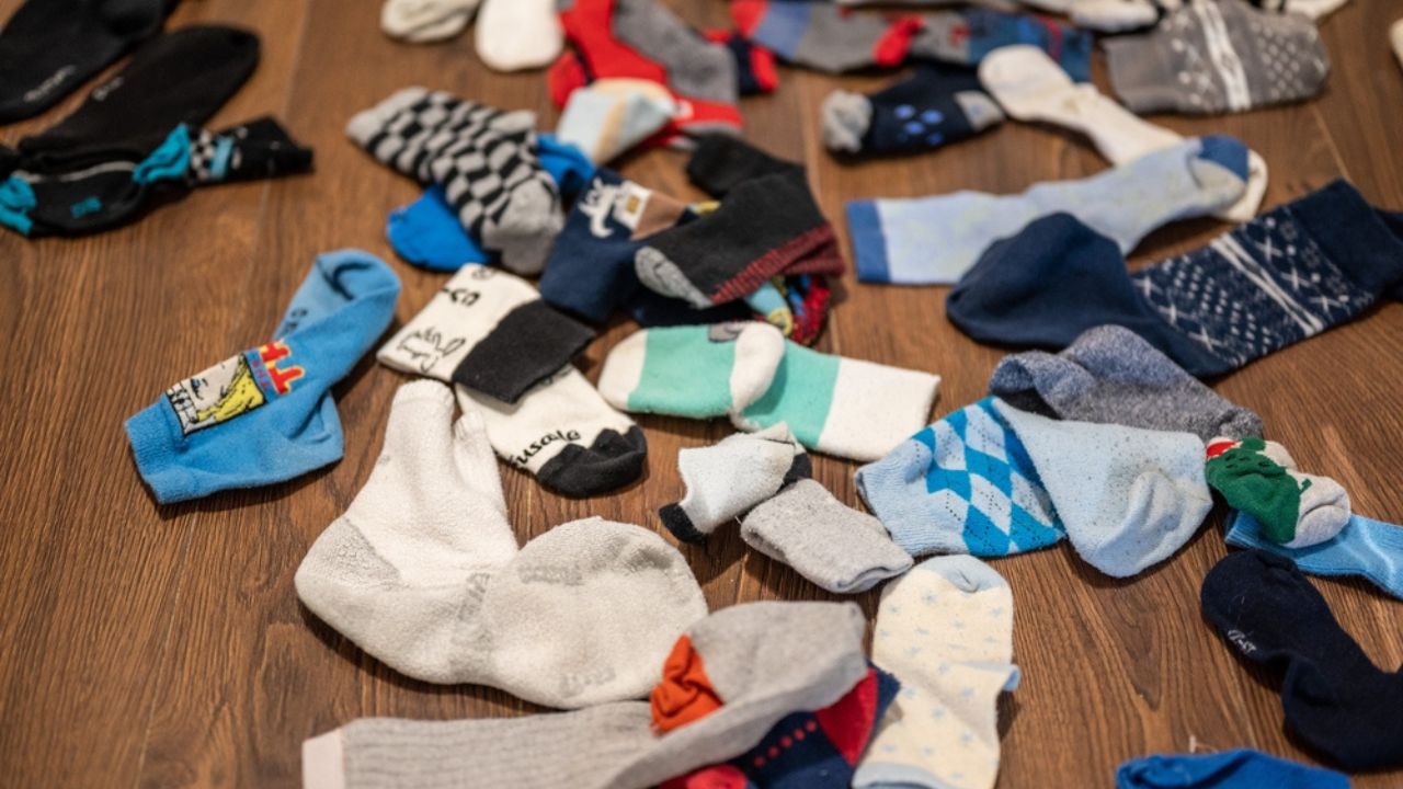 Bunch of clean unpaired socks on a wooden floor