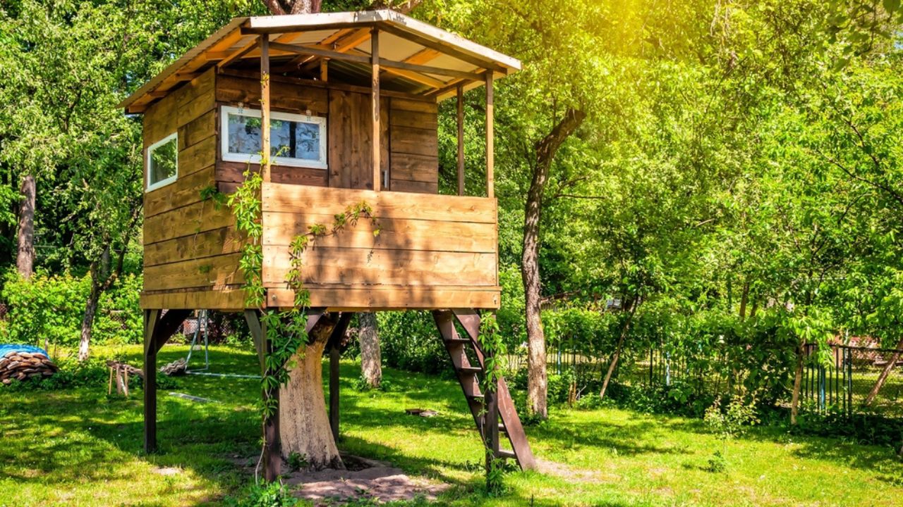 Handmade tree house in sunny green garden