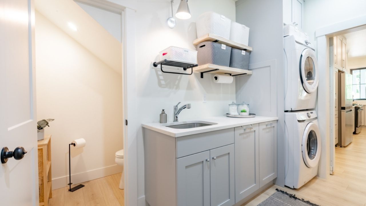 Laundry room and mud room waiting area coat rack hooks baskets shoes washing machine dryer cabinets cupboards interior home
