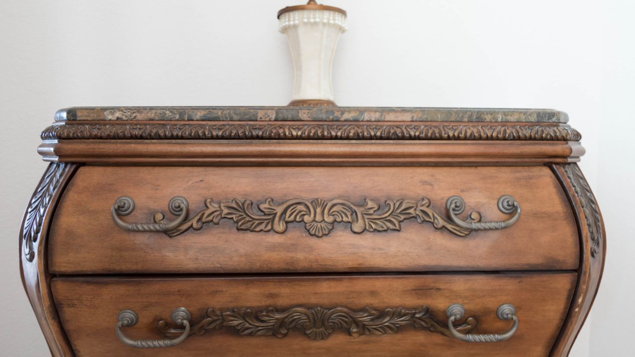 Luxurious brown dresser with intricate wood carvings on an antique design. Stylish furniture for an old house with vintage feel.