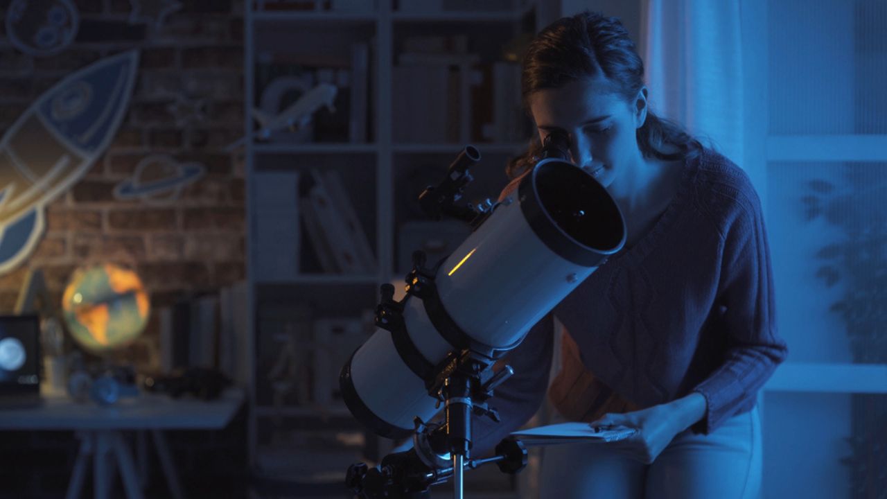Young smart woman studying astronomy and watching the stars using a telescope, science and discovery concept