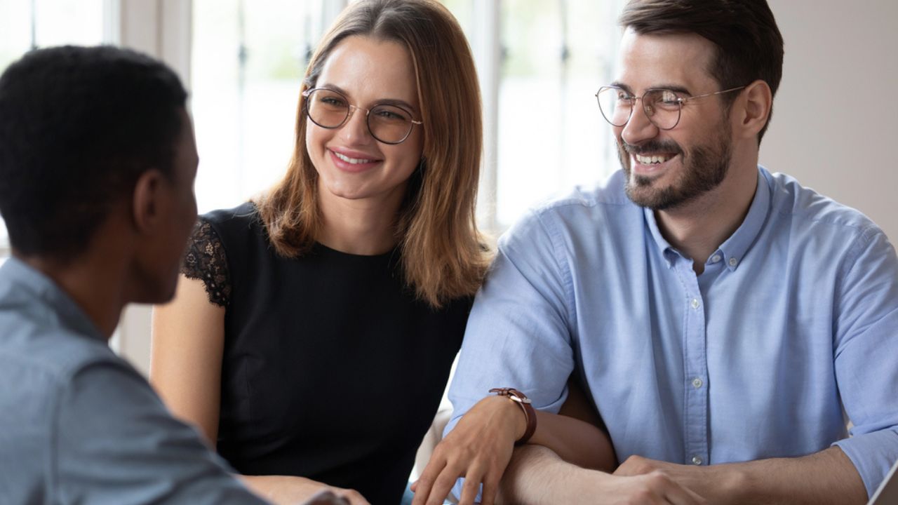 African Agent Consulting Young Caucasian Spouses in Office
