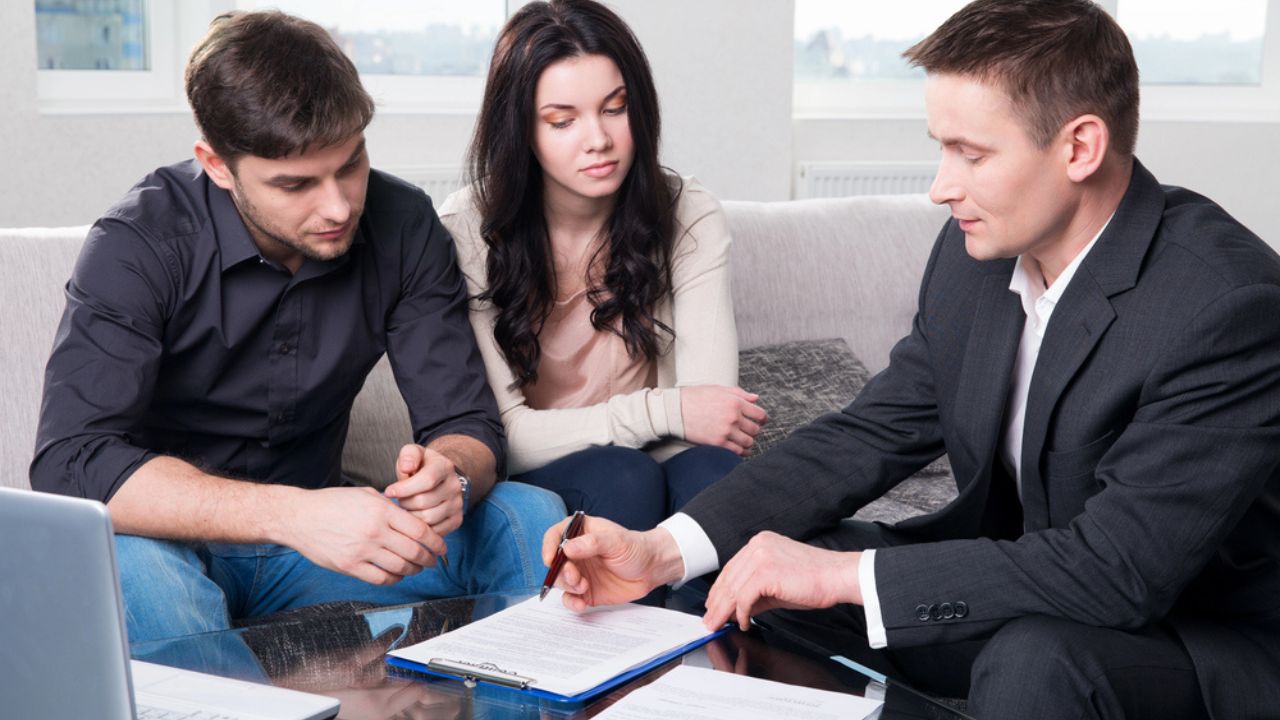 Agent advises the couple, signing documents