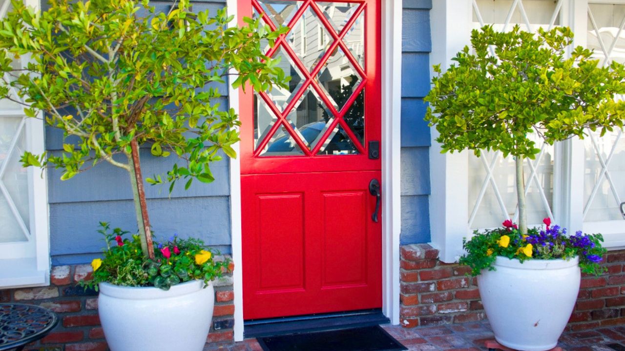 Classic beach cottage with bright red Dutch door and with topiaries