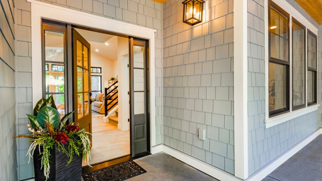 Front entry door of a modern home showing interior staircase and porch