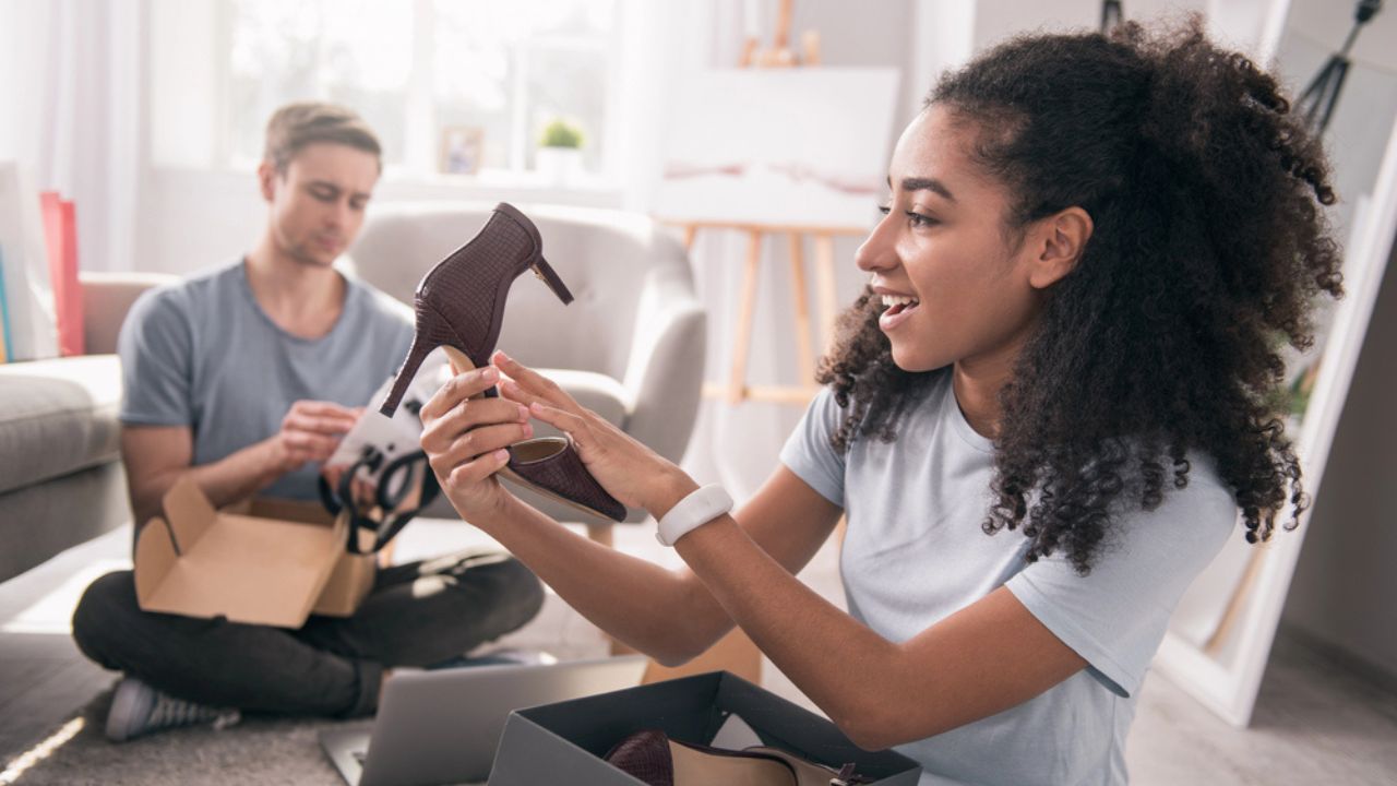 Pleasant cheerful woman looking at the new shoes