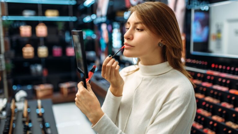 Female customer testing lip liner in makeup shop