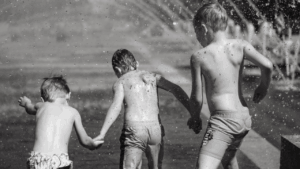 black and white boys in the sprinkler