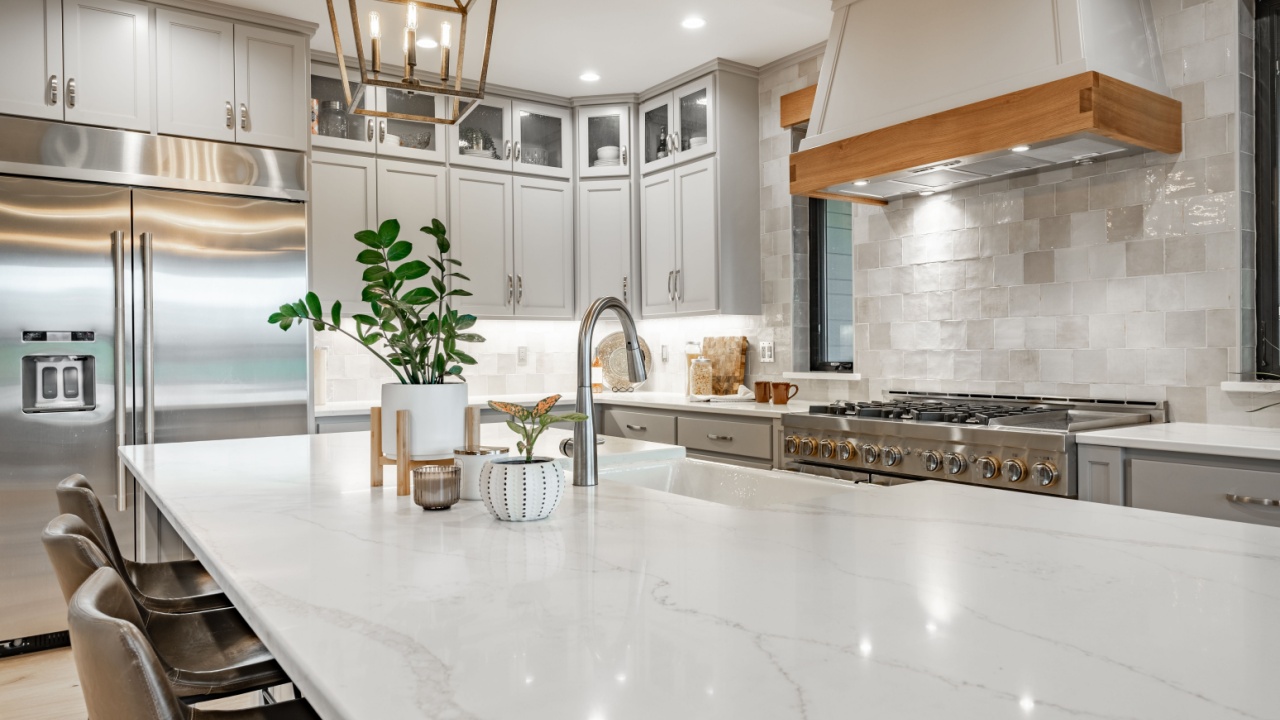 Interior modern farmhouse kitchen and dining room with white countertops bar stools large dining table stainless appliances and view to living room with vaulted ceiling
