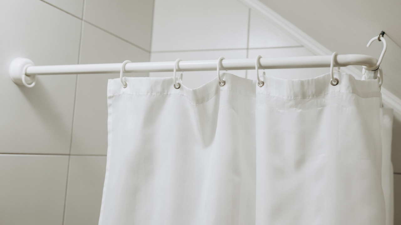White bathroom with white shower curtain.