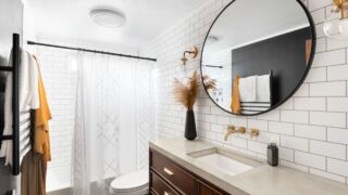Bathroom photo with classic white subway tile with large concrete top vanity, modern light fixtures, heated towel rack, and white shower curtain.