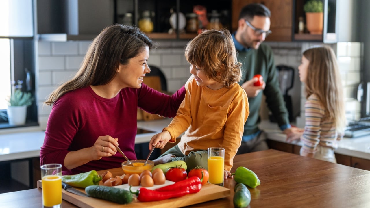 Happy family is cooking together in a bright kitchen, showing joy, teamwork, and love at home