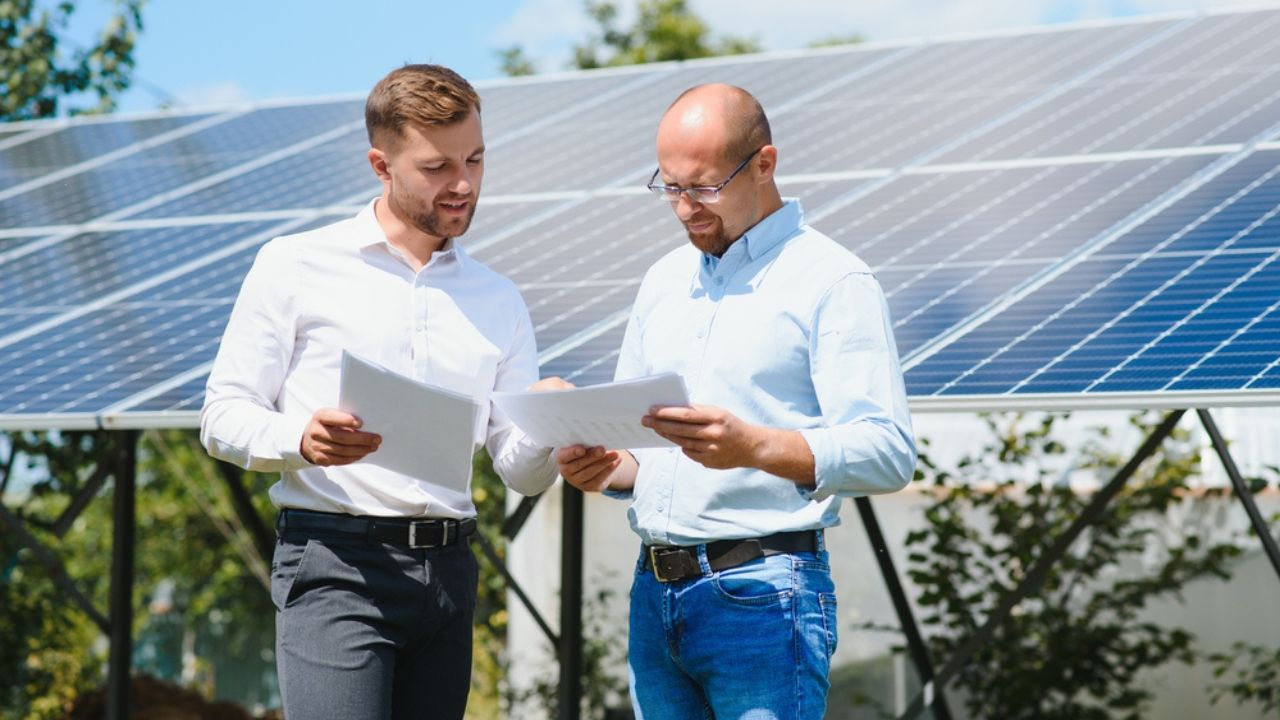 Two People Having a Shaking Hands against Solar Panel after the Conclusion of the Agreement in the Renewable Energy