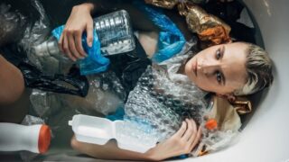 woman sitting in trash and clutter
