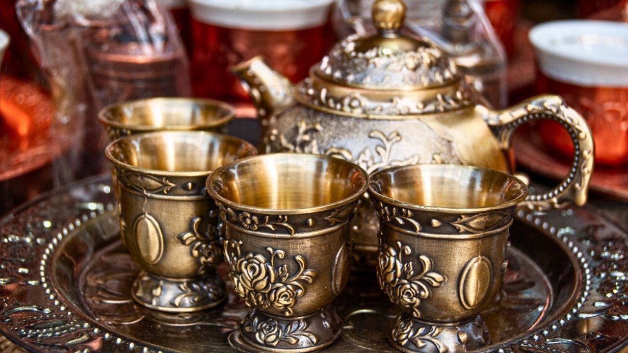 Vintage copper tea set displayed elegantly in a traditional shop window.