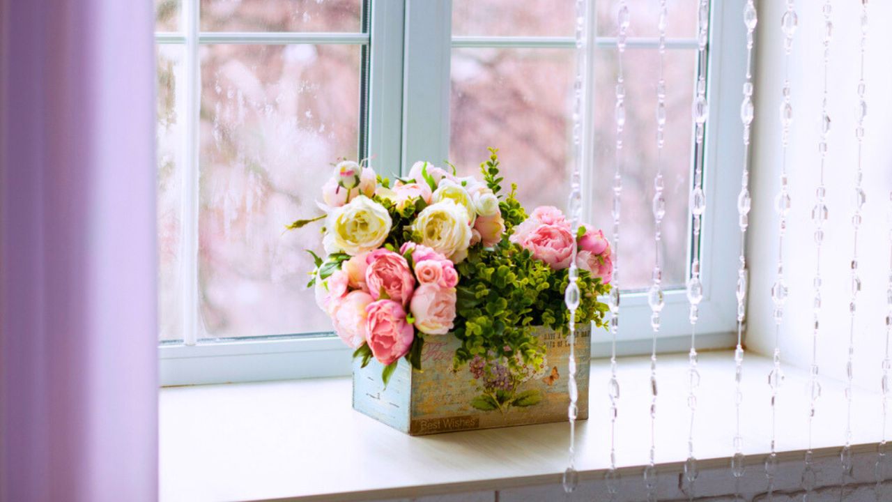 Window with curtains and flowers in paper box