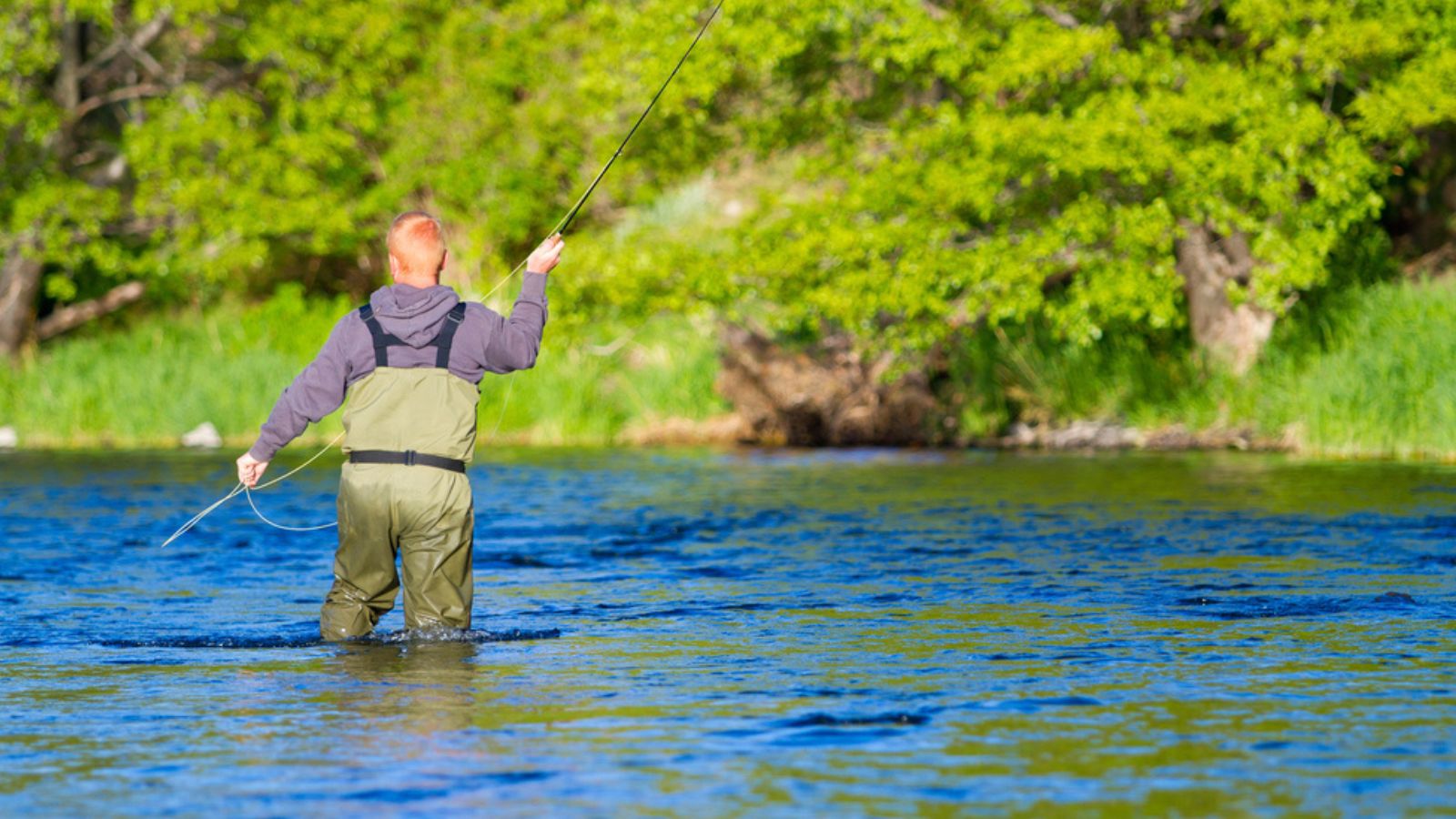A man standing in the water and fishing - recreational activity in Montana