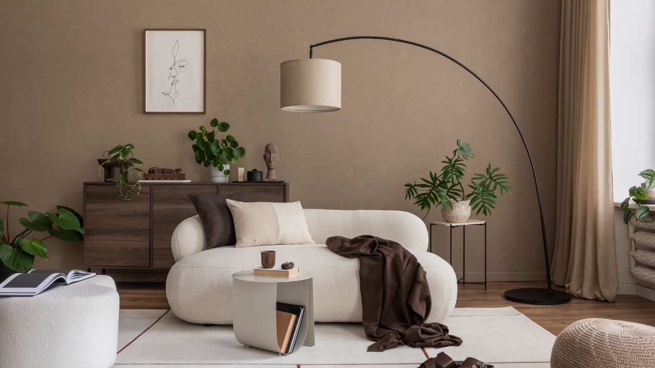 Stylish living room with a curved sofa, modern art, and a large floor lamp. Neutral colors and minimalist design offer a perfect space for relaxation. Template