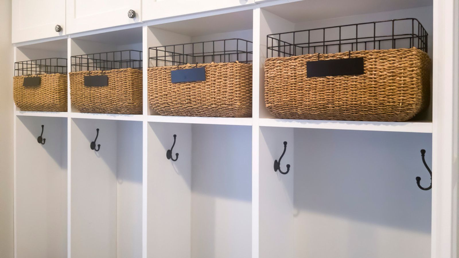 Fitted white wooden wall storage cabinet with shelves hooks and doors