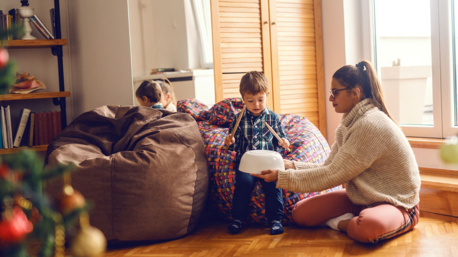 Little boy sitting in bean bag and pretending to play drums