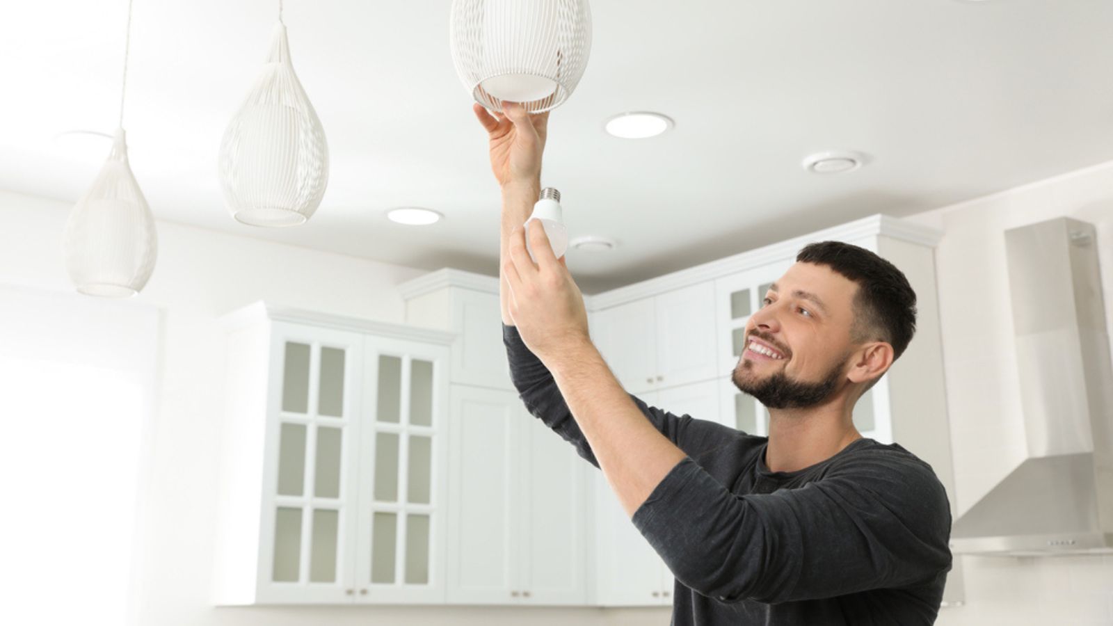 Man changing light bulb in lamp at home.