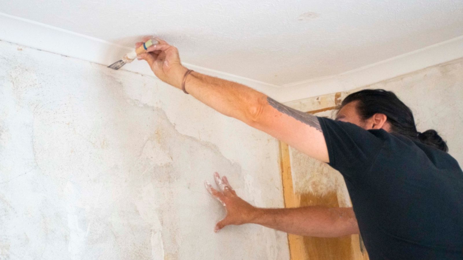 Man renovation walls plastering cracks in wall interier